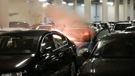 Samochód w płomieniach na parkingu galerii
